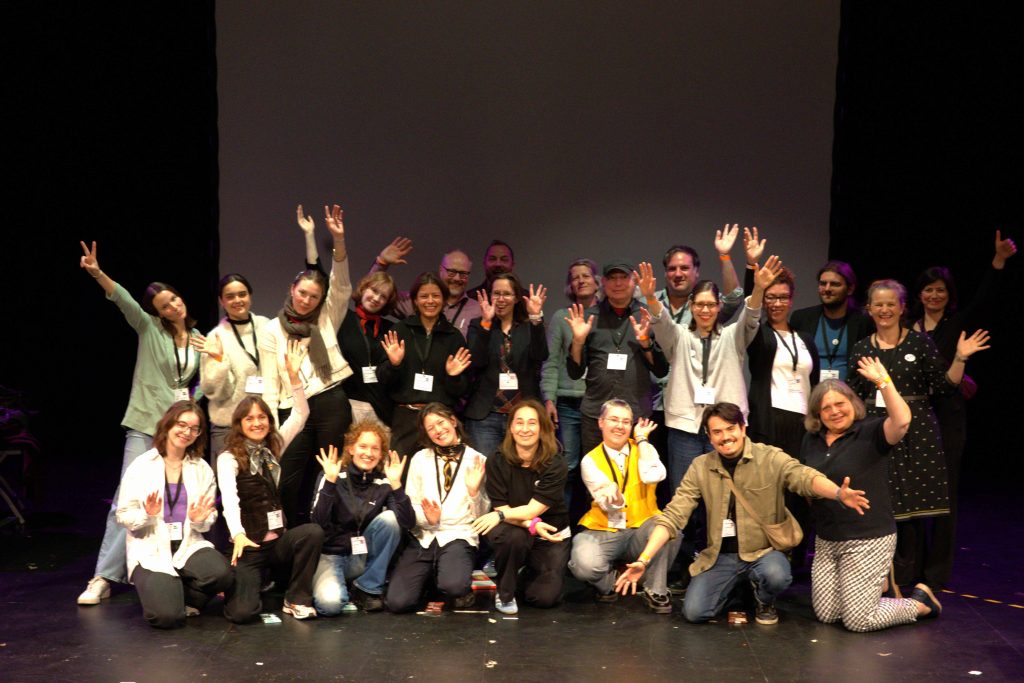 Gruppenbild von allen Leuten, die die Connected Audience Conference mitorganisiert haben, auf der Bühne des Theater Strahl in Berlin.